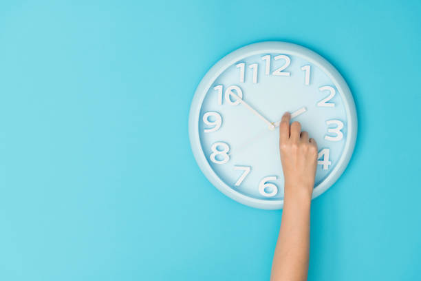 mano humana ajustando el reloj de la hora - clock hand fotografías e imágenes de stock