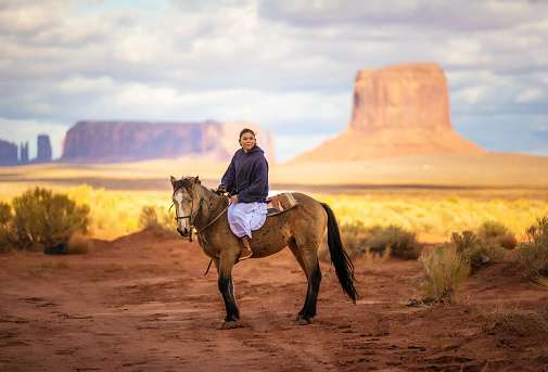 Native american indian riding horse on Navajo Nation’s Monument Valley Park