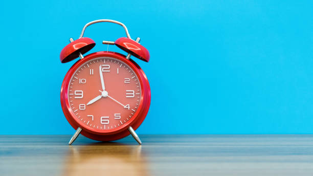 istock Red alarm clock on the wooden table 1289665167
