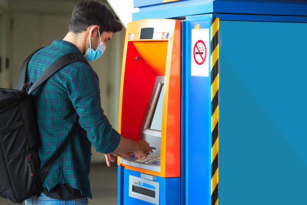 istock Caucasian man doing a financial transaction at a cash machine. 1289665910