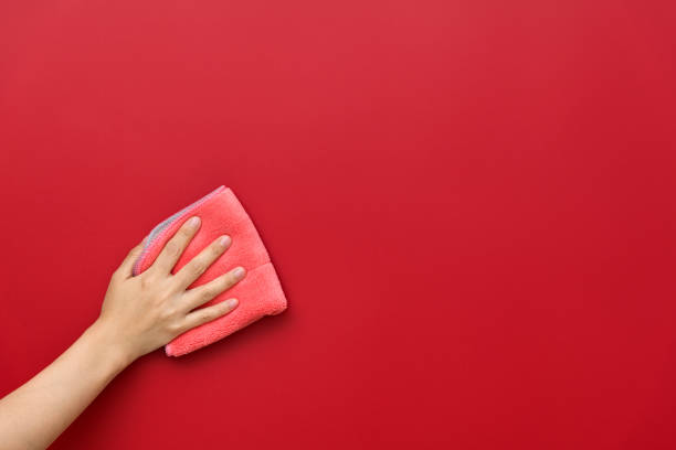 istock Woman hand cleaning red wall with rag 1289666111