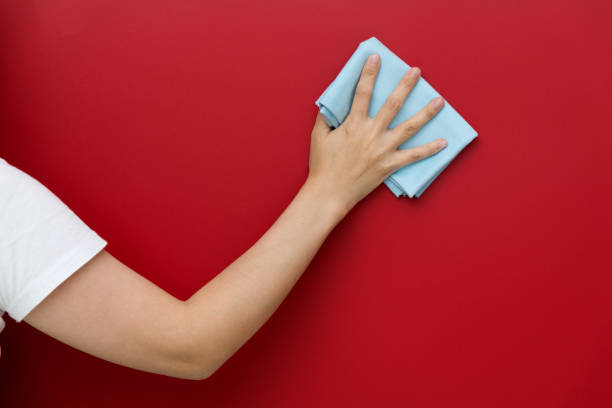 istock Woman hand cleaning red wall with rag 1289666707
