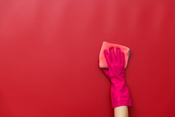 istock Woman hand cleaning red wall with rag 1289667553