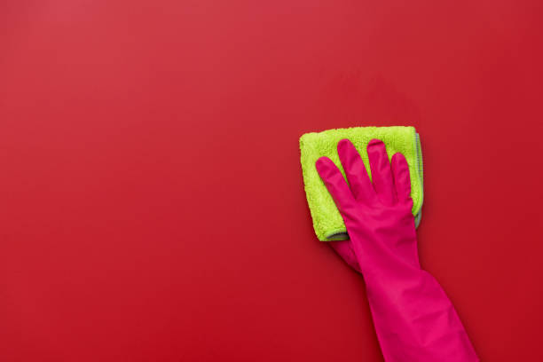istock Woman hand cleaning red wall with rag 1289667583