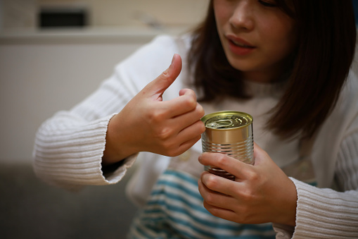 A woman whose fingers hurt because she couldn't open the can
