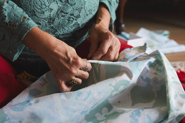 istock Mature woman is sewing by hand with needle, thread and thimble 1289668644