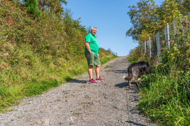 istock Senior Caucasian man and dog on uphill path 1289669251