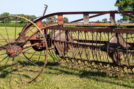 Close up view of an antique tractor-drawn windrower farm implement, used for cutting grain which was then laid in rows for drying and threshing.