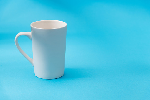 White mug on blue background.