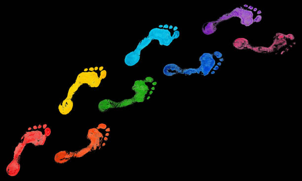 istock Rainbow color human footprints way black background isolated, colorful neon light barefoot footstep pattern, foot print walking path illustration, bare feet route trail imprint, stamp, mark, wallpaper 1289674560