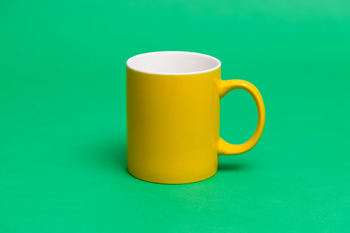 Yellow mug on green background