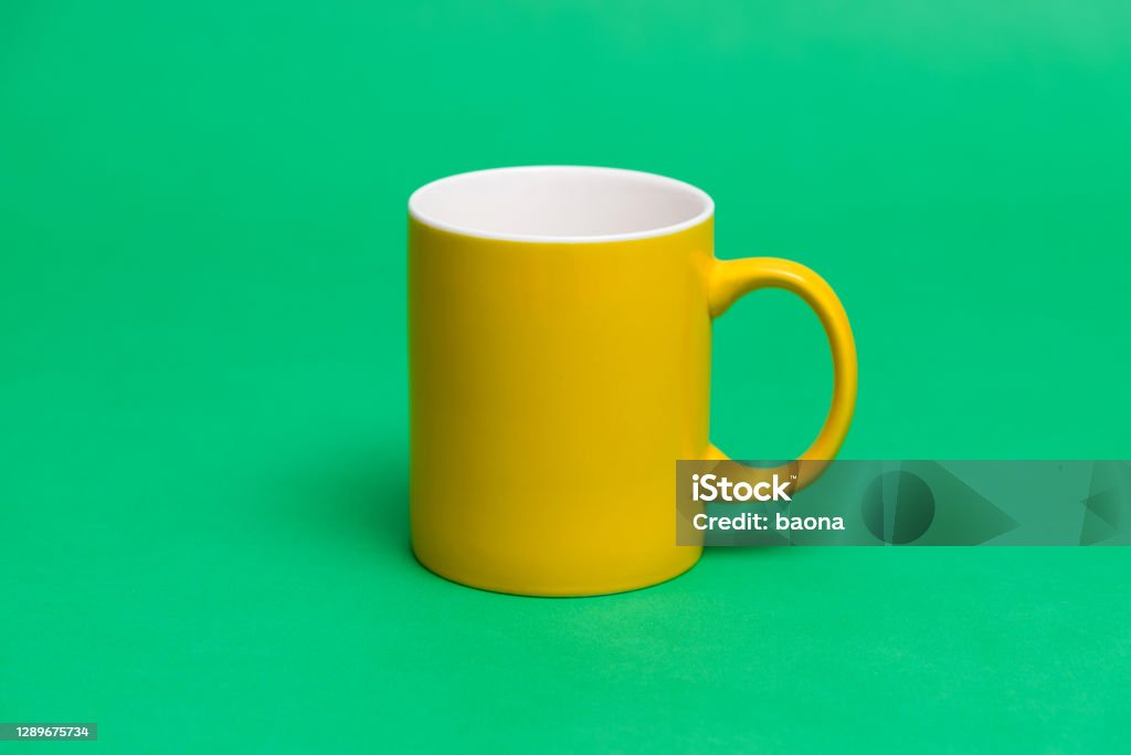 Yellow mug on green background Yellow mug on green background. Coffee Cup Stock Photo