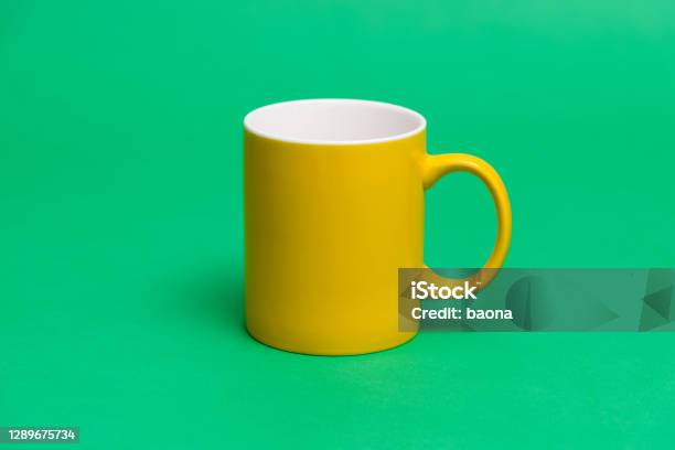 Yellow Mug On Green Background Stock Photo - Download Image Now - Coffee Cup, Cup, Colored Background