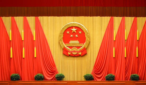 National emblem of China at the Great Hall of the People in Beijing, China National emblem of the People's Republic of China and Red flags at the Great Hall of the People in Beijing, China politburo stock pictures, royalty-free photos & images