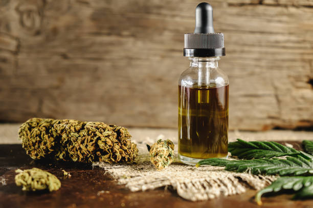 a vial with a dropper of cannabis concentrate cbd stands next to dried marijuana buds and a cannabis leaf on a rusty wooden and sackcloth background. copy space a vial with a dropper of cannabis concentrate cbd stands next to dried marijuana buds and a cannabis leaf on a rusty wooden and sackcloth background. copy space. horizontal orientation cannabis store photos stock pictures, royalty-free photos & images