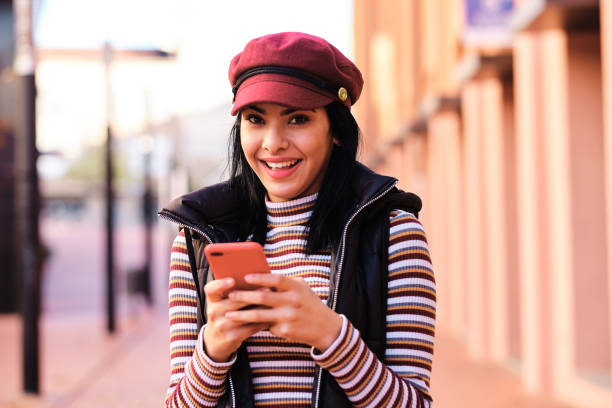 istock young middle east girl using a red smartphone outdoors 1289683184