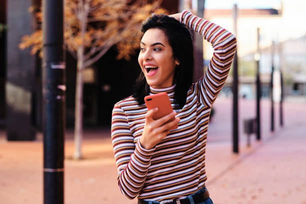 istock young middle east girl using a red smartphone outdoors 1289683211