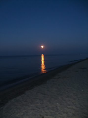 The Night on the Sea Beach Showing a Shiny Reflection of the Moonlight Over the Sea.
