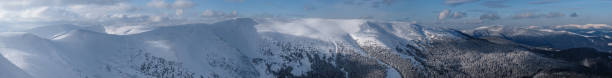 istock Snow and wind formed ice formations covered winter mountain plateau, tops with snow cornices in far. Magnificent sunny day on picturesque beautiful alpine ridge. 1289688095