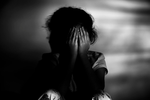 anxiety of a child concept, little girl sitting in the floor, dark room, stock photo