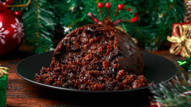 istock Christmas pudding with decoration, gifts, green tree branch on wooden rustic table 1289690747