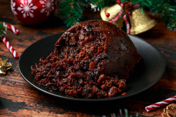 istock Christmas pudding with decoration, gifts, green tree branch on wooden rustic table 1289690768