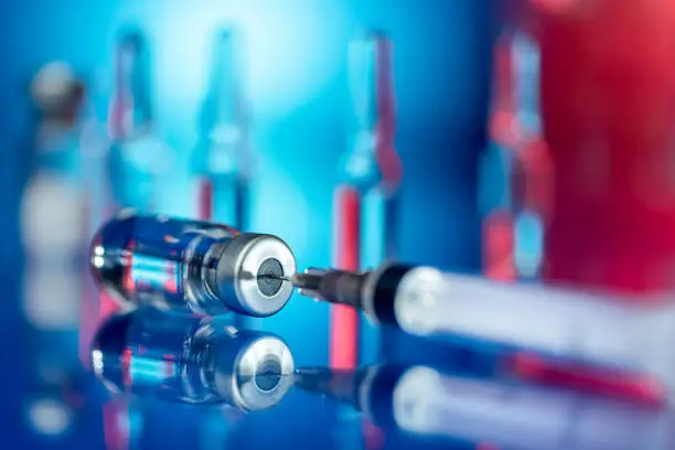 Photo of Vaccines and syringe in a laboratory