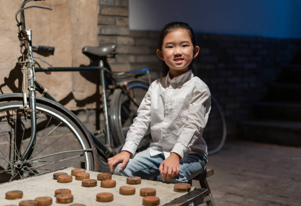 petite fille jouant aux échecs chinois - chinese chess leisure games chinese culture traditional culture photos et images de collection