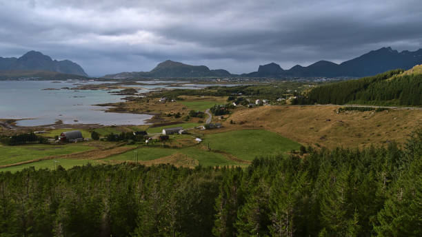 bela vista panorâmica a oeste da ilha de vestvågøy, lofoten, noruega com fiordes buksnesfjorden, cidade de leknes, montanhas ásperas, campos agrícolas e floresta de árvores coníferas. - vestvagoy - fotografias e filmes do acervo