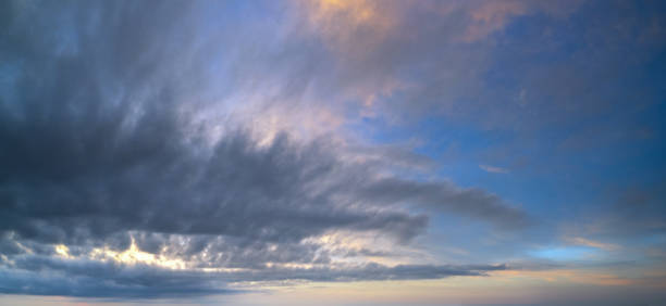 istock Fluffy clouds in evening overcast sky panoramic view. Climate, environment and weather concept sky background. 1289695925
