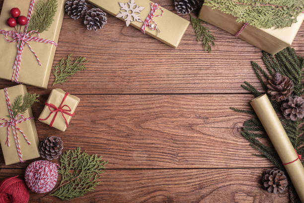 istock Christmas decoration with pine cone and gift boxes on brown rustic board. 1289697362