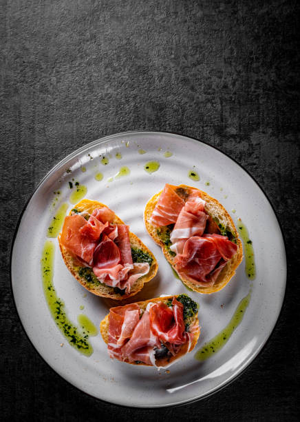 istock Bruschetta with prosciutto and pesto sauce on plate 1289699257