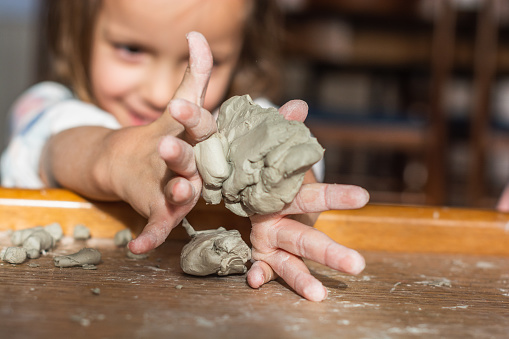 Close-up of children hands molding toy clay at home