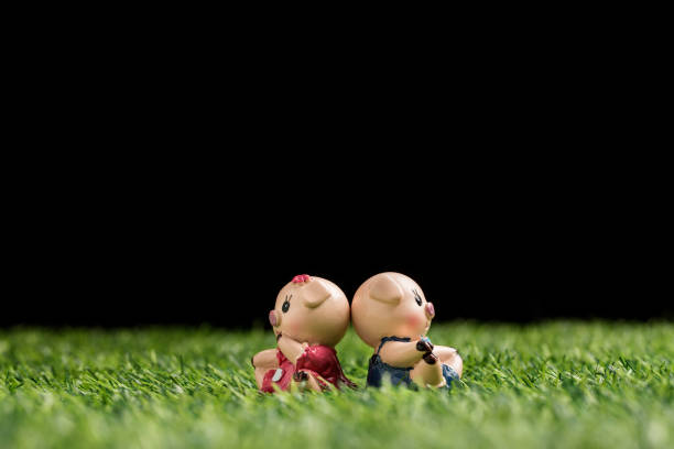 Baby doll lays on the green grass
