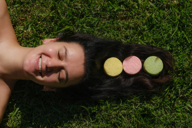 istock Young woman laying on the grass with natural eco friendly solid shampoo bar or conditioner on her hair. Zero waste and sustainable plastic free lifestyle 1289703985