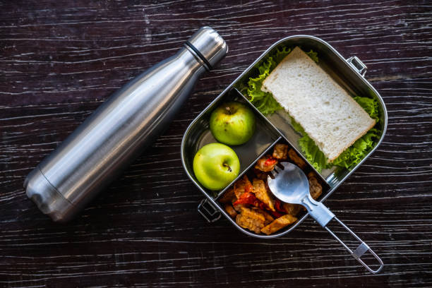 stainless steel food container or lunch box with healthy vegetarian meal and reusable thermo bottle on wooden background. eco-friendly kitchen products. zero waste sustainable plastic free lifestyle - lunch box lunch box metal imagens e fotografias de stock