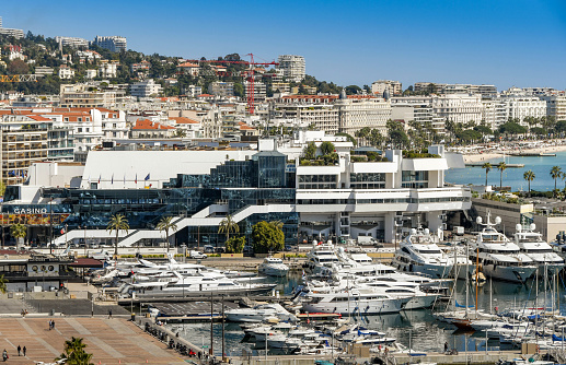 Cannes, France - April 2019: View overlooking the marina in Cannes with the bay in the background. The large building houses a casino.