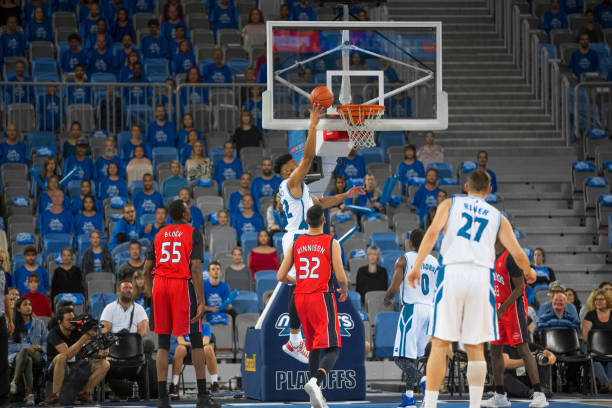 istock Basketball player jumping to score slam dunk 1289707347