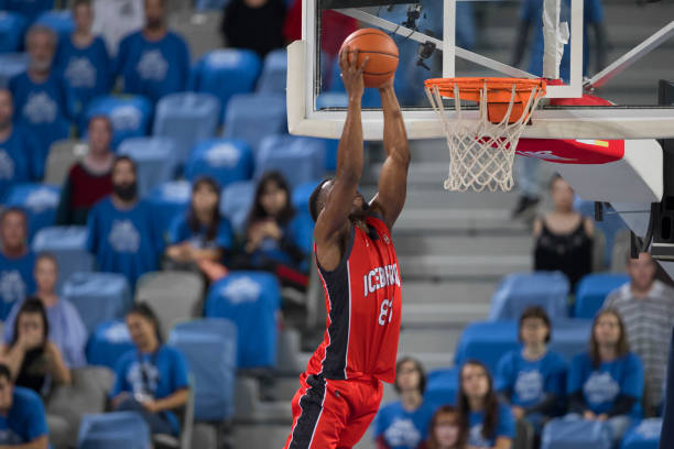 istock Basketball player jumping to score slam dunk 1289707403