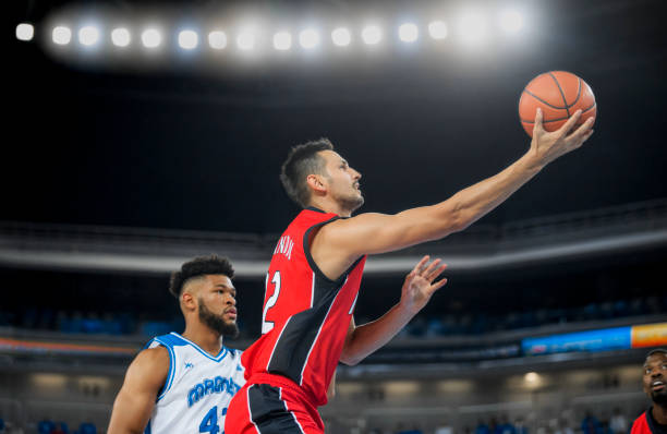 istock Basketball players playing on court 1289707423