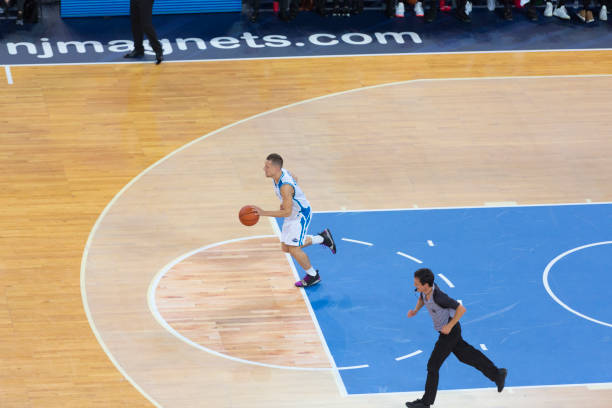 istock Basketball player dribbling ball 1289707444