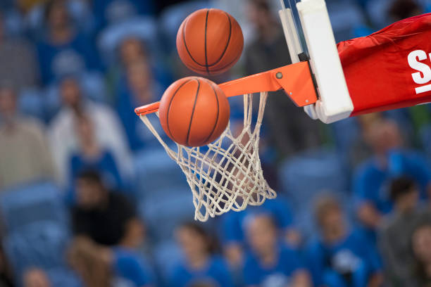 istock Basketballs reaching to hoop 1289707499