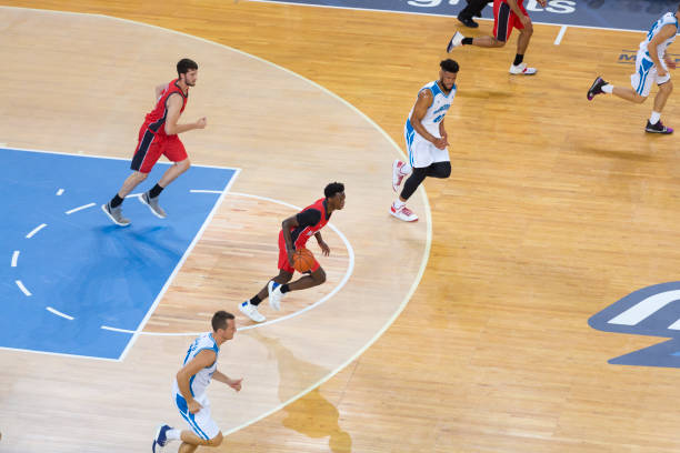 istock Basketball players playing on court 1289707553