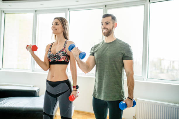 istock Fit young couple doing home workout with dumbbells 1289709456