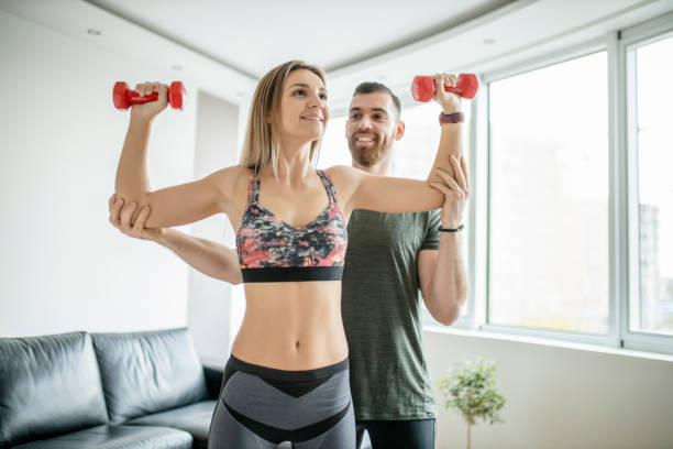 istock Fit young couple doing home workout with dumbbells 1289709924
