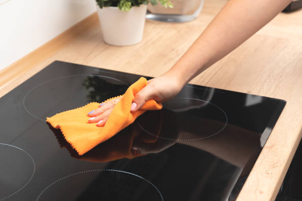 istock Woman cleaning induction stove 1289711172