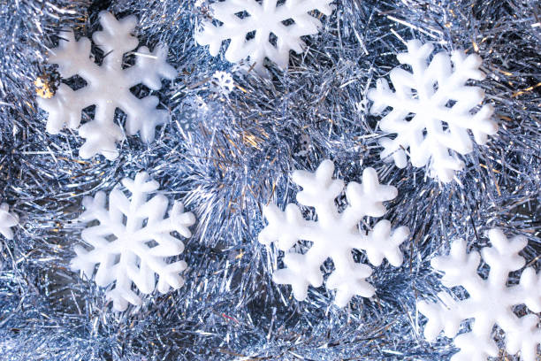 istock Christmas decorative snowflakes lying on a silver sparkling background. 1289715395
