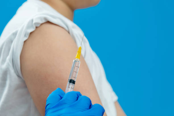 istock Doctor vaccinating for a boy on blue background 1289715431