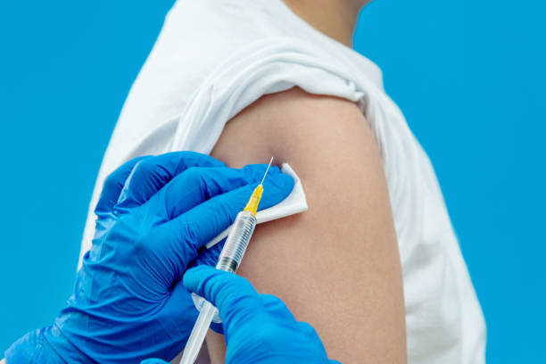 istock Doctor vaccinating for a boy on blue background 1289715559