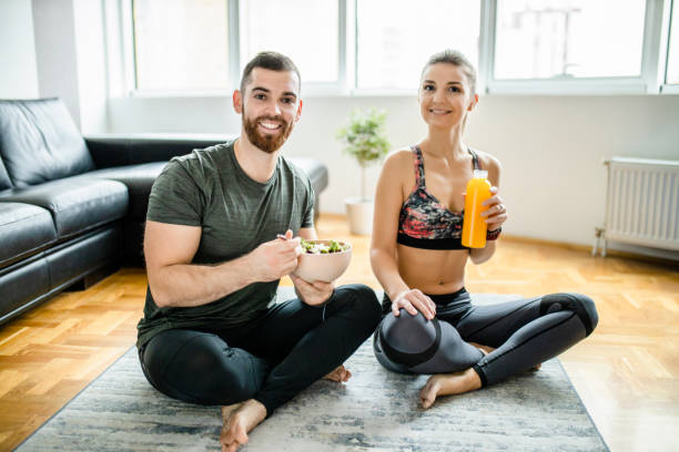 istock Fit couple eating snack after intensive home workout 1289715598